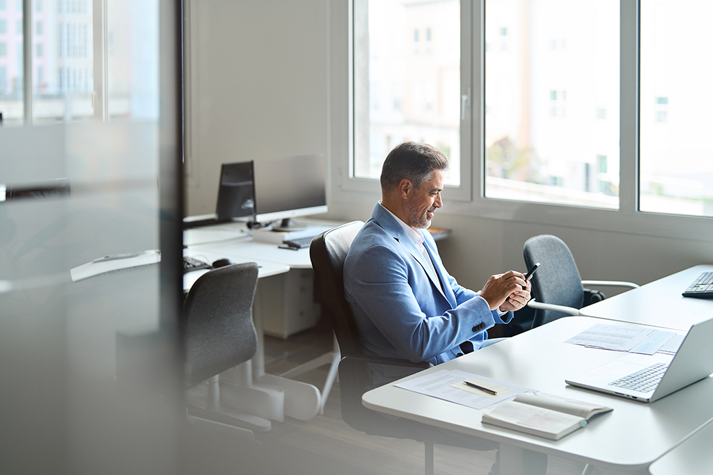 Business man using his phone at a table